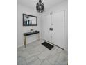 Bright foyer featuring a modern light fixture, console table, and tiled flooring at 613 Valley Hill Dr, Brandon, FL 33510