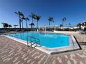 Large swimming pool with brick pavers, featuring lounge chairs and shaded pergola at 6357 Bahia Del Mar Blvd # 111, St Petersburg, FL 33715