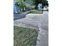 Long concrete driveway provides ample parking space alongside a well-maintained lawn at 7039 Woodibis Dr, New Port Richey, FL 34654