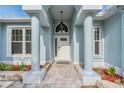 Detailed view of a home's arched entryway, framed by pillars and featuring a decorative glass front door at 7039 Woodibis Dr, New Port Richey, FL 34654