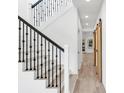 Open hallway with wood-look tile floors, iron-railed staircase and natural wood sliding barn door at 7113 S Kissimmee St, Tampa, FL 33616