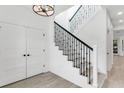 Bright foyer with an open staircase with iron railing and wood-look tile floors throughout at 7113 S Kissimmee St, Tampa, FL 33616