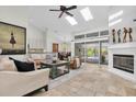 Spacious living room with skylights, a ceiling fan, fireplace, and views of the lanai and pool at 865 Live Oak Ne Ter, St Petersburg, FL 33703