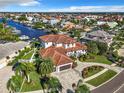 A captivating aerial view showcasing the home's tile roof, manicured lawn and canal access at 949 Symphony Isles Blvd, Apollo Beach, FL 33572