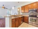 Well-lit kitchen with stainless steel appliances and wooden cabinets at 9823 Rolling Cir, San Antonio, FL 33576