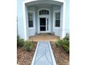 Inviting entryway featuring a decorative walkway and sheltered porch at 11752 Wayside Willow Ct, Hudson, FL 34667