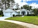 Charming single-story home featuring a well-maintained lawn, two-car garage, and a lovely covered entryway at 11752 Wayside Willow Ct, Hudson, FL 34667