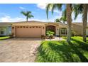 Charming single-story home with a paved driveway, well-manicured lawn, and a two-car garage at 12918 Royal George Ave, Odessa, FL 33556