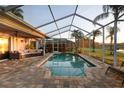 Inviting screened-in pool area featuring a brick patio, comfortable seating, and views of the backyard at 12918 Royal George Ave, Odessa, FL 33556