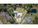Expansive property featuring a pool, generous lawn, and a serene pond, all within a lush, tree-lined setting at 1305 Greenfield Cir, Venice, FL 34292