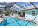 Inviting screened-in pool area with a hot tub, seating, and ample space for relaxation at 1305 Greenfield Cir, Venice, FL 34292