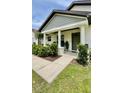 Inviting front porch of home with a well-maintained lawn and beautifully landscaped bushes at 13486 English Sparrow Rd, Weeki Wachee, FL 34614