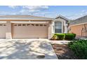 Exterior view of a home's two-car garage and landscaped front yard at 31434 Shaker Cir, Wesley Chapel, FL 33543