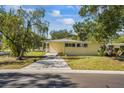 Inviting single-story home with a long driveway and lush green lawn at 3600 46Th N St, St Petersburg, FL 33713