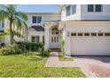 Charming front exterior with lush landscaping, brick driveway and a two-car garage at 417 Ventura Dr, Oldsmar, FL 34677