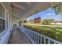 Inviting covered porch with hanging flower baskets and a view of the front yard at 4340 Narvarez S Way, St Petersburg, FL 33712