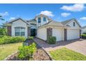 Inviting home featuring a well-manicured lawn, stone accents, and a two-car garage at 5518 72Nd E Ter, Ellenton, FL 34222
