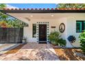 Inviting front entrance with decorative door and tile accents, potted plants create a welcoming atmosphere at 6213 12Th S Ave, Gulfport, FL 33707