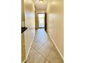 Well-lit hallway with tiled flooring leading towards a bright, sunlit entrance at 6446 Louisiana Ave, New Port Richey, FL 34653