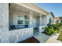 Inviting front porch with seating area, decorative wreath, and classic design at 7420 Cay Dr, Port Richey, FL 34668