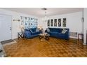 Bright living room featuring hardwood floors, comfortable blue couches, and decorative lighting at 7420 Cay Dr, Port Richey, FL 34668