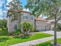 Charming two-story home with manicured lawn, mature trees, and ample parking in a three car garage at 7927 Hampton Lake Dr, Tampa, FL 33647