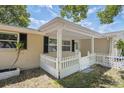 Close up view of the front porch area with white columns and a matching white picket fence at 8733 Goshen Ln, Port Richey, FL 34668