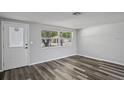 Bright living room with new wood-look floors and a decorative front door at 8733 Goshen Ln, Port Richey, FL 34668