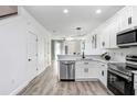 Bright kitchen featuring white cabinets, stainless steel appliances, and modern lighting at 8742 Turnstone Haven Pl, Tampa, FL 33619