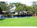 Lush backyard with canal access, showcasing waterfront living and mature trees for added privacy at 8817 Audrey Ln, Tampa, FL 33615