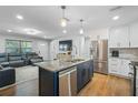 Open-concept kitchen featuring a large island with seating, stainless steel appliances, and seamless flow into the living area at 9653 Golden Grove St, Seminole, FL 33772