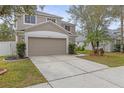 Charming two-story home boasts a well-manicured lawn, complemented by lush tropical landscaping and a two-car garage at 10525 Lucaya Dr, Tampa, FL 33647