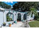 Inviting front entrance with a stucco archway, decorative planters, and a walkway at 10907 Kewanee Dr, Temple Terrace, FL 33617
