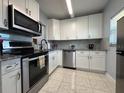 Bright kitchen featuring stainless steel appliances, granite countertops, and white cabinetry at 11485 Oakhurst Rd # 319, Largo, FL 33774