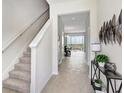 Bright foyer with staircase, tile flooring, and stylish decor welcomes you into this spacious home at 11718 Blackbrook Ct, Seffner, FL 33584