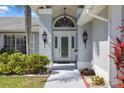 This home boasts a covered entry, beautiful double doors, and mature landscaping at 13528 Woodside Dr, Hudson, FL 34667