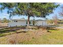 Charming single-story home boasts a pristine white exterior, complemented by a well-kept lawn and mature trees at 1499 Janet Pl, Englewood, FL 34223