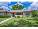 Charming single-story villa with a well-manicured lawn, sidewalk and mature trees at 150 James Ct, Oldsmar, FL 34677