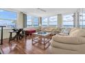 Bright living room filled with windows and water views, featuring comfortable seating and stylish decor at 17408 Gulf Blvd # 1302, Redington Shores, FL 33708