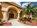 Front porch with an arched entryway, double doors, and palm trees in the front yard at 2042 Diamond Ct, Oldsmar, FL 34677