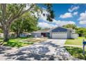 Inviting home with a two-car garage, front yard landscaping, and concrete driveway at 2671 Clubhouse N Dr, Clearwater, FL 33761