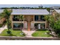 Bright canal-front duplex with private balconies, lawn, and palm tree landscaping at 2675 St Josephs E Dr # C, Dunedin, FL 34698