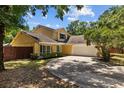 Lovely yellow home featuring an attached garage and a well-manicured yard at 305 Bryan Oak Ave, Brandon, FL 33511