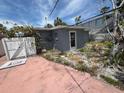 View of backyard with white fence, side door, and small outdoor space at 310 79Th Ave, St Pete Beach, FL 33706