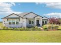 Charming one-story home featuring stone accents, manicured landscaping, and a lush green lawn at 32860 Drake Estates Way, Dade City, FL 33525