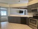 The kitchen showcases stainless steel appliances, tile floors, white countertops, and gray cabinetry at 3414 Berry Blossom Ln, Plant City, FL 33567