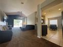 Inviting living room featuring vaulted ceilings, neutral paint, ceiling fan and sliding glass door to back yard at 3414 Berry Blossom Ln, Plant City, FL 33567
