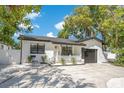 Charming renovated one-story home featuring a white exterior, dark accents, and well-manicured landscaping at 3512 Haines N Rd, St Petersburg, FL 33704