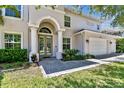 Inviting home exterior highlighting the arched entryway, manicured landscaping, and attached three-car garage at 3710 W San Pedro St, Tampa, FL 33629