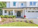 Covered front porch with brick floor leading to a double front door, surrounded by lush landscaping at 3821 W Vasconia St, Tampa, FL 33629